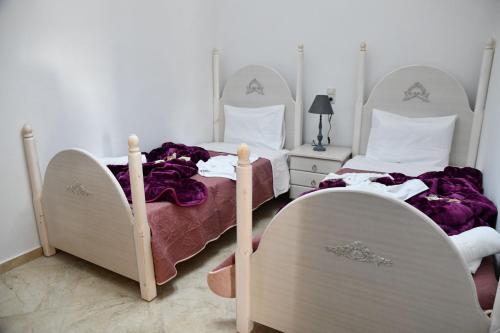 two twin beds in a bedroom with purple sheets at Kleopatra Deluxe Apt with priavte Jacuzzi in Kamilari