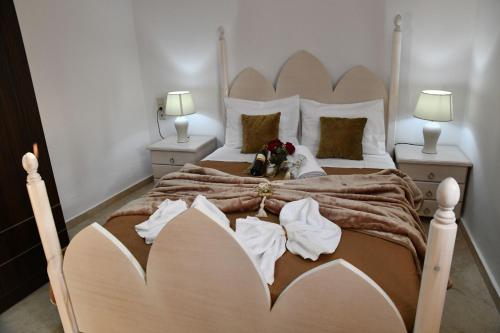 a bedroom with a large bed with two lamps at Cleopatra deluxe with jacuzzi apart in Kamilari with panoramic view in Kamilari