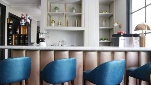 a bar with blue chairs in a restaurant at Hotel Shalva Jakarta in Jakarta
