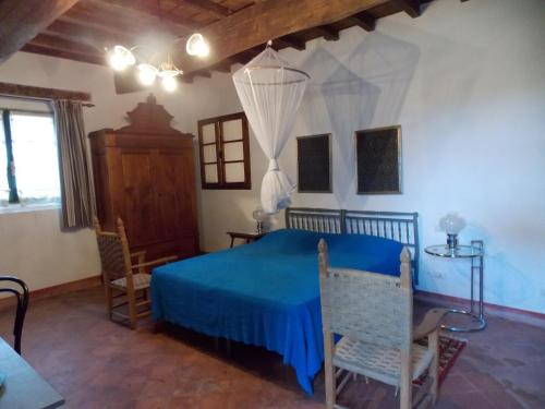ein Schlafzimmer mit einem blauen Bett in einem Zimmer in der Unterkunft Bed and Breakfast di Charme La Bonarella in Russi