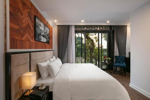 a bedroom with a large white bed and a balcony at Marina Hotel in Hanoi