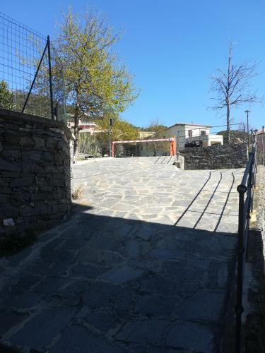 a large stone patio with a fence and trees at Casa Anna in Moneglia