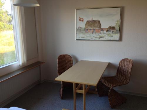 
a room with a table and chairs and a window at Hotel Vadehavet in Rømø Kirkeby
