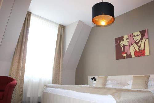 a bedroom with a white bed and a black lamp at 1.Republic Hotel in Prague