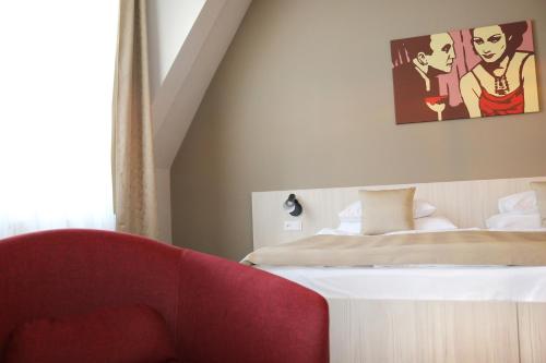 a bedroom with a bed and a red couch at 1.Republic Hotel in Prague