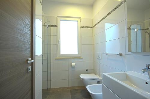 ein Badezimmer mit Toilette und Waschbecken und einem Fenster in der Unterkunft *Amazing modern apartment with 2 bedrooms* in Vodnjan