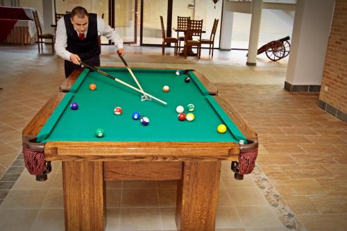 a man playing pool on a pool table at Hotel Fajkier in Kroczyce