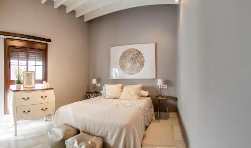 a bedroom with a bed and a dresser in it at Espectacular ático con terraza en Triana in Seville