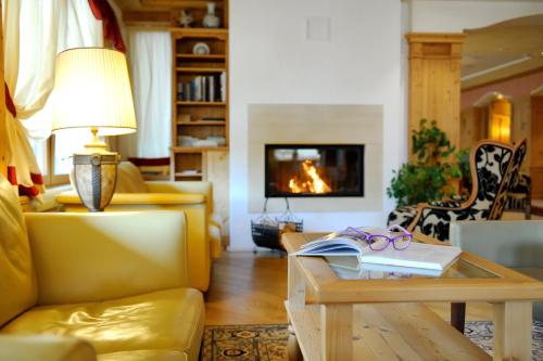 a living room with a yellow couch and a table at Boutique Hotel Diana in Madonna di Campiglio