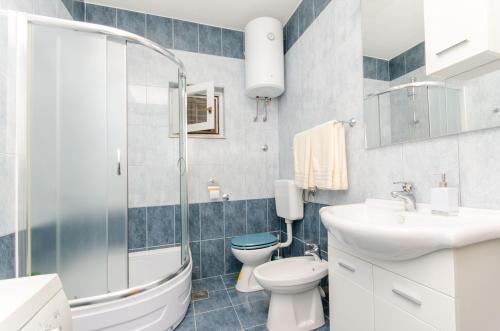 a bathroom with a toilet and a sink and a shower at Apartman Ivan in Kaštela