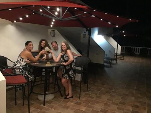 a group of people sitting at a table under an umbrella at Hotel Los Cielos Del Caribe in Cahuita