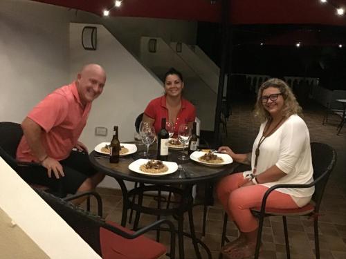 a group of people sitting around a table with food at Hotel Los Cielos Del Caribe in Cahuita
