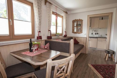 a dining room with a table and a kitchen at Apart Angela in Mayrhofen