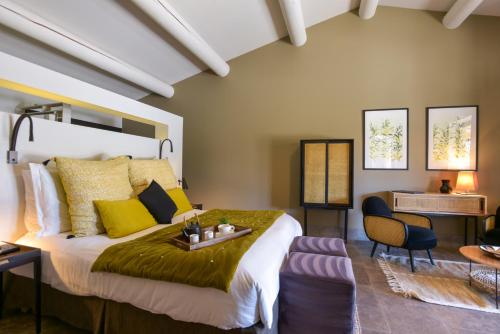 une chambre avec un grand lit avec des oreillers jaunes dans l'établissement Domaine la Pierre Blanche, à Eygalières