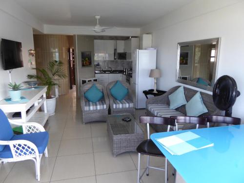 ein Wohnzimmer mit einem Sofa und einem Tisch in der Unterkunft Seaview Apartment Amanzimtoti in Amanzimtoti
