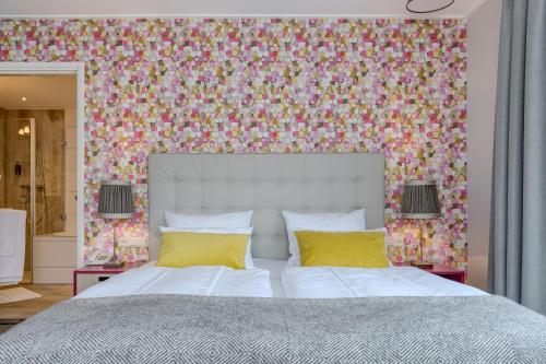 a bedroom with a large bed with a floral wallpaper at Hotel Op Diek in Den Hoorn