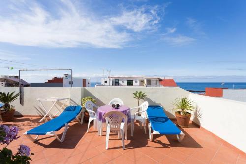 a patio with a table and chairs and the ocean at Apartamento 3 en Casa Rosamar in Puerto de la Cruz