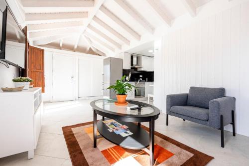 a living room with a table and a chair at Loft 1º de Maio in Tavira