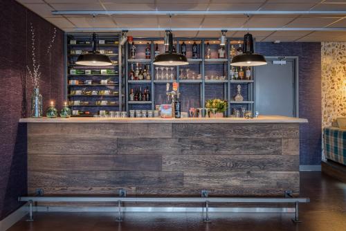un bar avec un mur en bois et un banc dans l'établissement Hotel Op Diek, à Den Hoorn