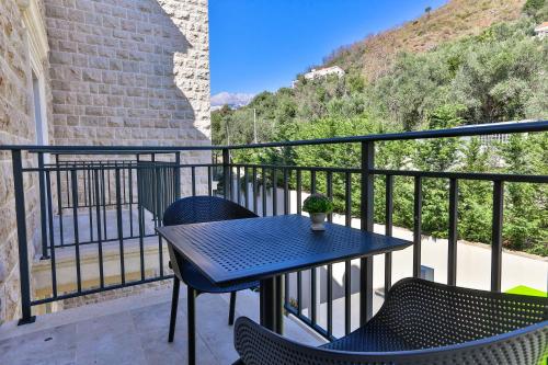 a patio with a table and chairs on a balcony at Hotel California by Aycon in Sveti Stefan