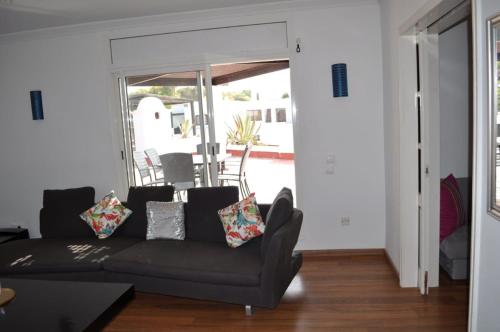 a living room with a black couch and a sliding glass door at Royal Golf Appartement Deluxe in El Jadida