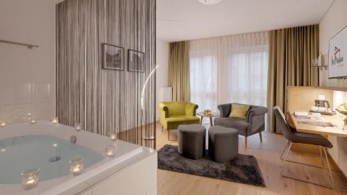 ein Badezimmer mit Badewanne und ein Wohnzimmer in der Unterkunft Hotel Moselauen in Bernkastel-Kues