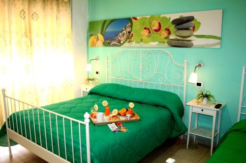 Un dormitorio con una cama verde con una bandeja de comida. en B&B Dolcevita, en Pompeya