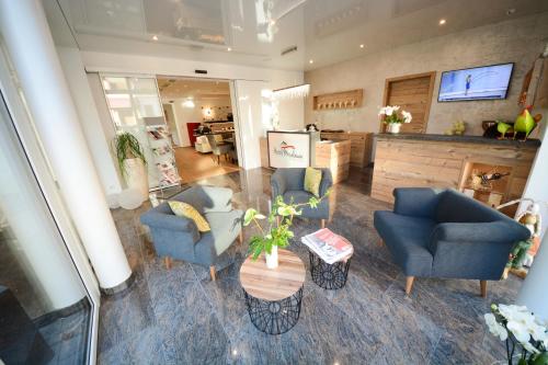 a living room with two blue chairs and a table at Hotel Moselauen in Bernkastel-Kues