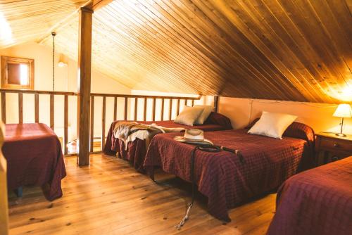 Habitación con 3 camas y techo de madera. en Camping Fort Bravo, en Tabernas