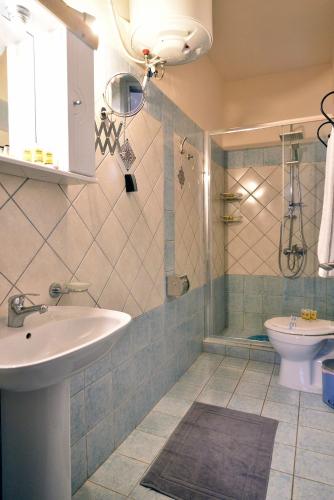a bathroom with a sink and a shower and a toilet at Nikolas Rooms in Chania