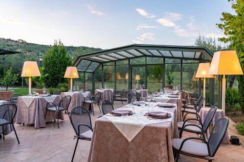a group of tables and chairs in a patio at Villa Borgo San Pietro in Cortona