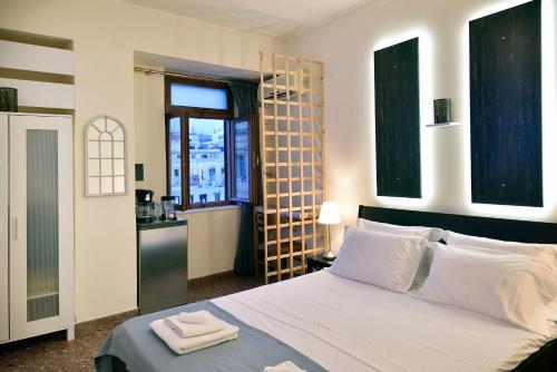 a bedroom with a large white bed and a kitchen at Nikolas Rooms in Chania Town