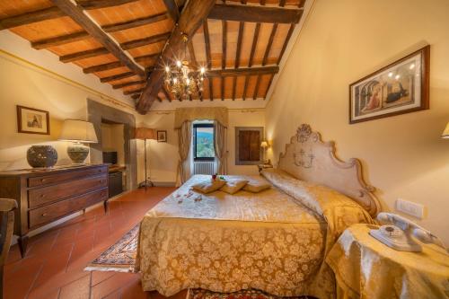 ein Schlafzimmer mit einem großen Bett und einer Holzdecke in der Unterkunft Villa Borgo San Pietro in Cortona