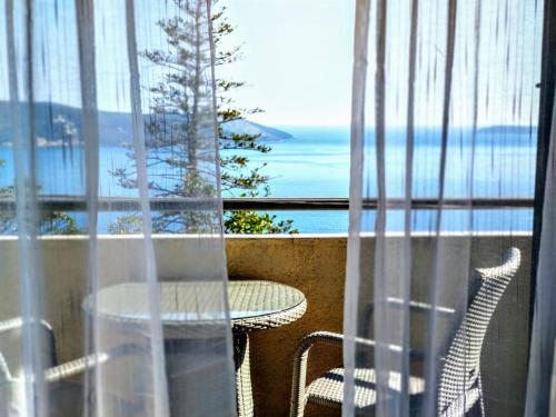 einen Balkon mit einem Tisch und Meerblick in der Unterkunft Apartments "Belle Vue" in Herceg-Novi