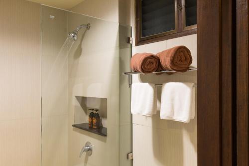 a bathroom with a shower and white towels at J4 Samui Hotel - SHA Plus in Chaweng