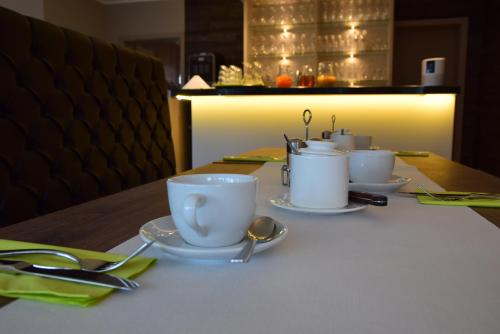 a table with white cups and saucers on it at Fisher's Inn in Zingst