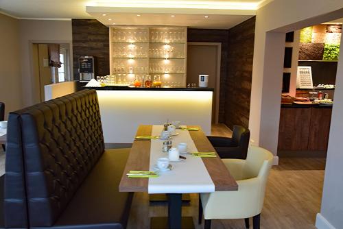 a dining room with a table and a bar at Fisher's Inn in Zingst