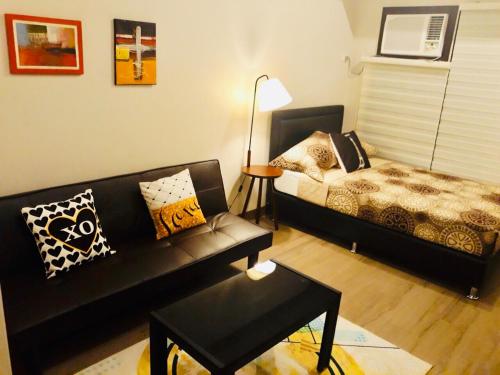 a living room with a couch and a bed at The Sentinel Residences Suite in Manila