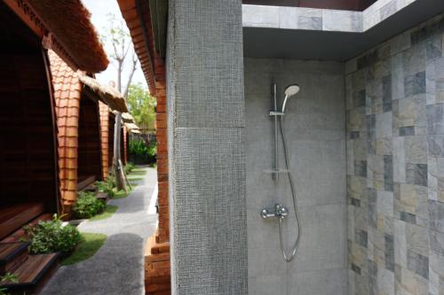 y baño con ducha en la pared. en Poedja Villa Jimbaran, en Jimbaran