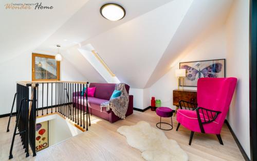a living room with pink chairs and a couch at Wonder Home - Apartamenty w zielonej okolicy, nad rzeką Łomnicą - blisko centrum Karpacza in Karpacz