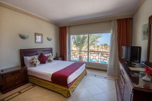 a hotel room with a bed and a large window at Imperial Shams Abu Soma in Hurghada