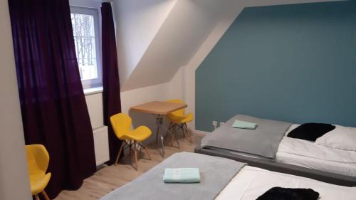 a bedroom with two beds and a table and chairs at Great Polonia Beach & Molo in Puck