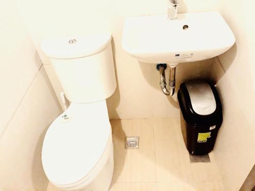 a bathroom with a white toilet and a sink at The Sentinel Residences Suite in Manila