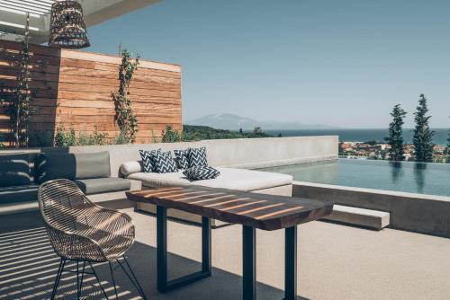 a patio with a table and chairs and a pool at Zante Maris Suites - Adults Only in Tsilivi