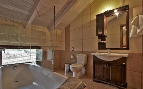 a bathroom with a tub and a toilet and a sink at Boutique Hotel Skamnos Arachova in Arachova