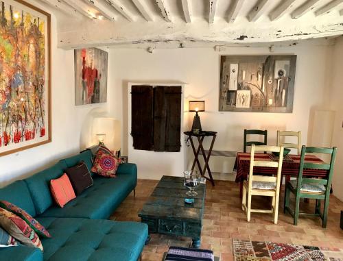 a living room with a blue couch and a table at Guest App'Art in Tourrettes-sur-Loup