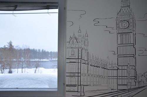 a window with a drawing of big ben and big clocks at Loft Family Hotel in Imatra