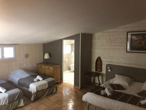 um quarto de hotel com duas camas e uma casa de banho em Le Mas Saint Donat em Sainte-Maxime