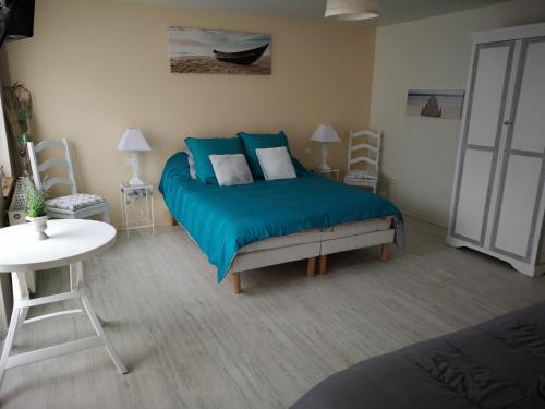 ThiergevilleにあるLes Chambres de Thiergevilleのベッドとテーブルと椅子のある寝室