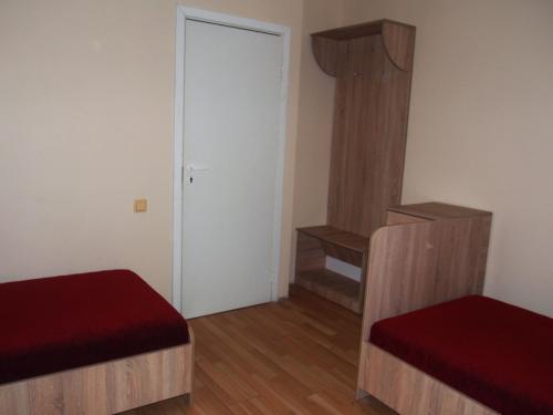 a small room with two beds and a door at Hostelis Laurita in Kaunas